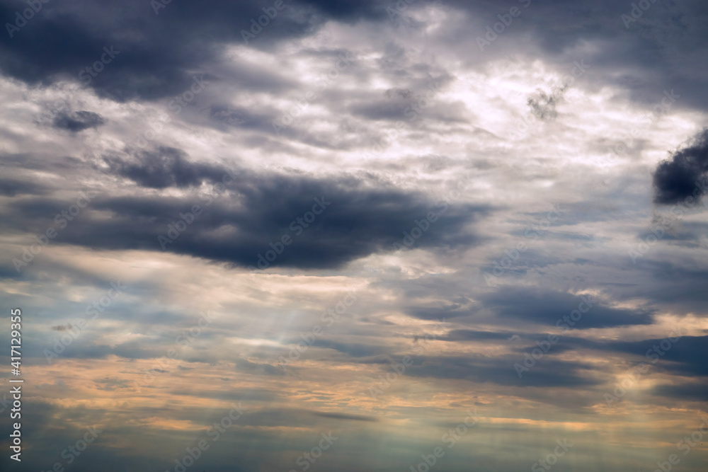 Obraz premium The sun's rays break through the clouds at sunset.
