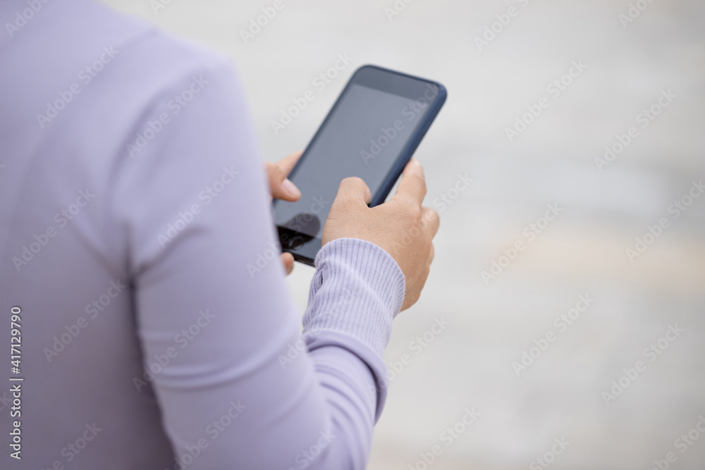 Asian woman using smartphone outdoors Asian woman using smartphone outdoors