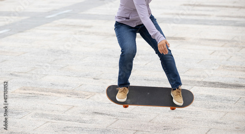 Asian woman skateboarder skateboarding in modern city