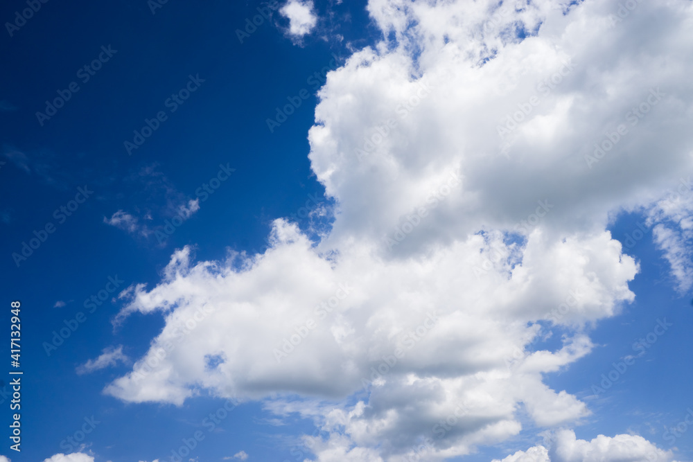 Obraz premium Bright cumulus clouds against a blue sky.