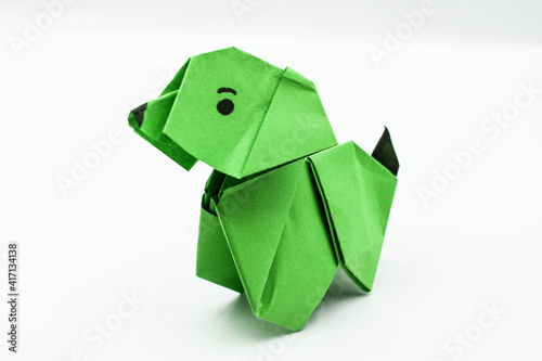 Green origami dog isolated on white background..