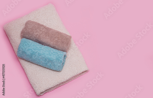 Clean towels on pink color background.  Massage, spa, hotel concept.