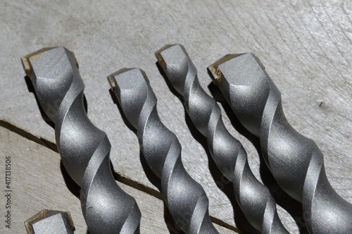 drills with carbide tip for impact drill lie on a plank wooden background. close-up. photo