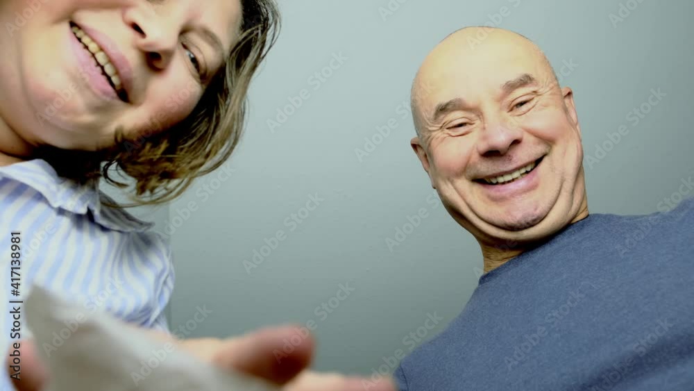 woman and a man opened a cardboard box with an ordered product, look into it, emotionally reacts to the contents, the concept of a postal item, a package, buying goods online