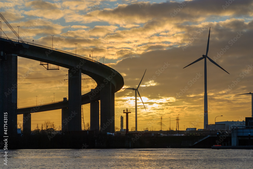 Hamburg, Germany: Koehlbrand Bridge and Wind turbine in Hamburg in the ligth of the sunset