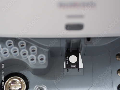 Closeup of dry chemistry analyzer and multilayered reagent coated slides for calculate the concentration of  substances within samples of serum. Hospital laboratories, automatic chemical analyzer.