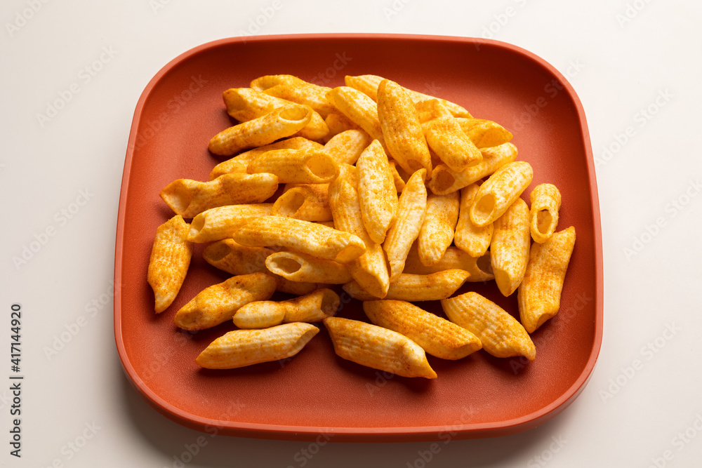 Crispy penne pasta shaped salty. Fast food or junk food snacks unhealthy concept. Crispy penne pasta shaped salty. Fast food or junk food snacks unhealthy concept.