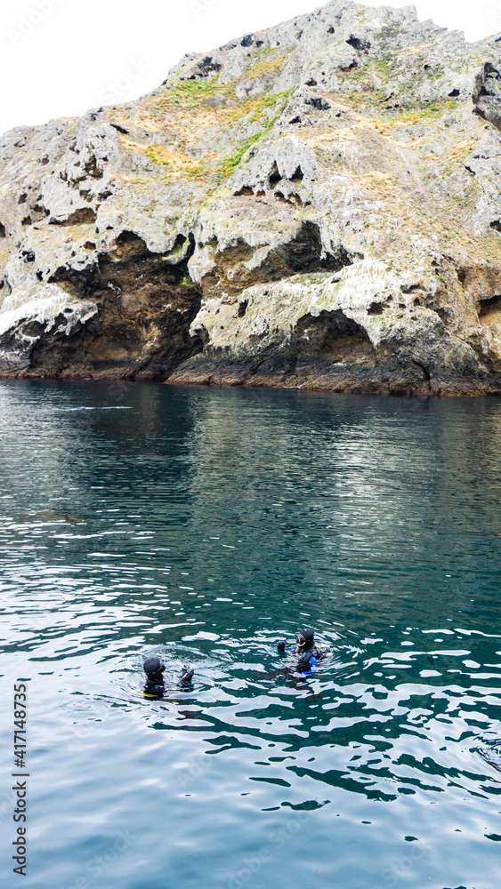 Dive buddies in front of Anacapa Cliffs in Channel Islands National Park, USA