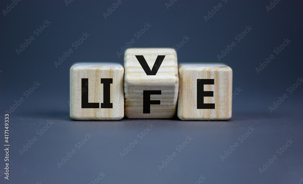 Live your life symbol. Turned cubes and changed the word 'live' to 'life'. Beautiful grey background, copy space. Business, live your life concept.