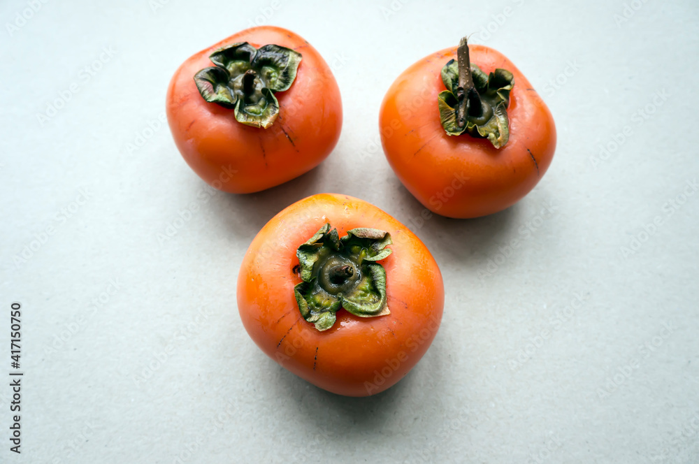 Three persimmon fruits on the table Three persimmon fruits on the table