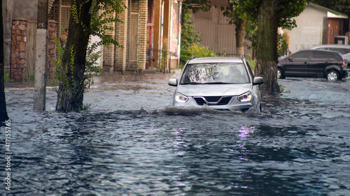 Canvas Print The car is moving down a flooded street.