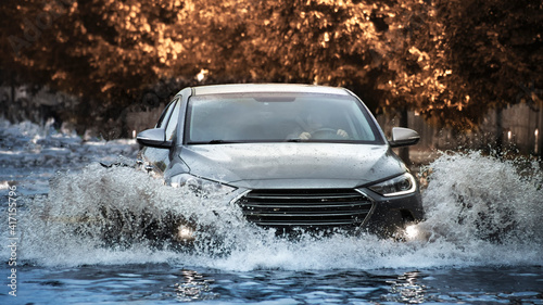 The car is moving down a flooded street.