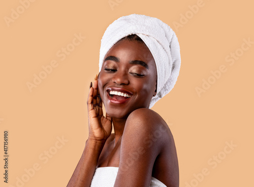 Portrait of young African woman with head towel touching face