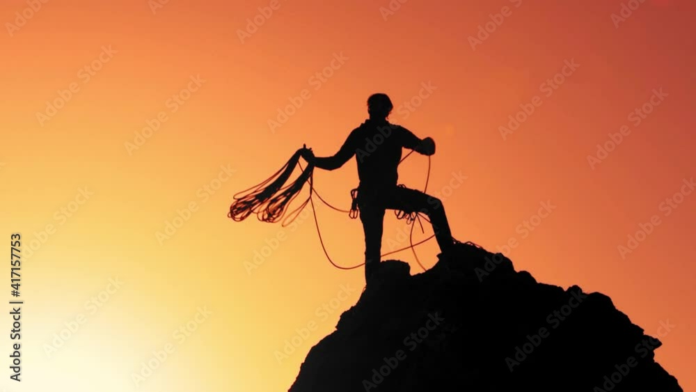 A climber on top of the rock prepares the rope