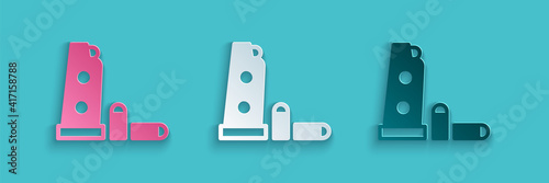 Paper cut Gun magazine and bullets icon isolated on blue background. Paper art style. Vector.