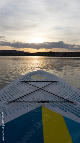 The front of a stand up paddle board on a lake (Lake Mead) during the sunrise in Nevada, USA © Tom H