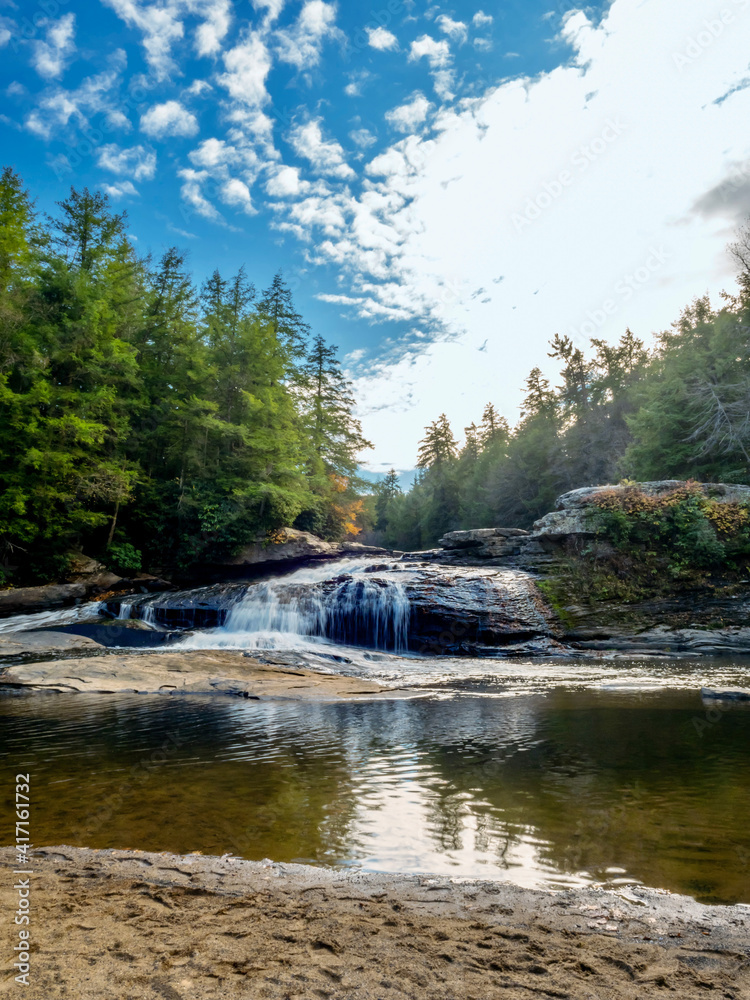 Obraz premium Swallow Falls State Park in the fall in the mountains of Maryland with the creek and waterfalls flowing, cascading in nature, fall foliage and trees to create the perfect fall water landscapes.