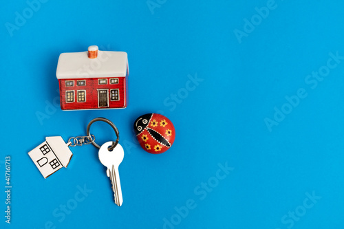 keychain, house and ladybug on blue background © Burcu Saritas