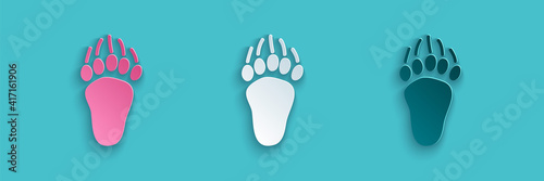 Paper cut Bear paw footprint icon isolated on blue background. Paper art style. Vector.