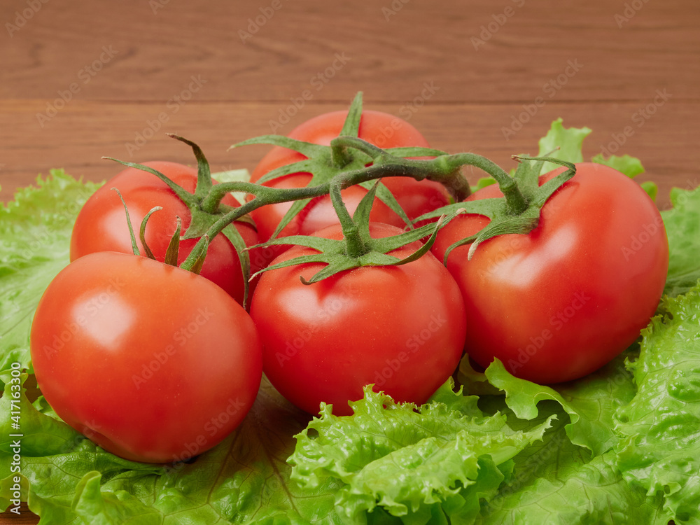 Fresh farm organic tomatoes and salad (lola rossa and lola bianca)on a rough wooden table on a sunny day. 100% Vegan, Vegetarian, Non-GMO Fresh farm organic tomatoes and salad (lola rossa and lola bianca)on a rough wooden table on a sunny day. 100% Vegan, Vegetarian, Non-GMO