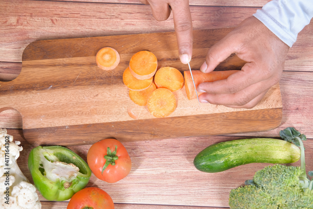 cutting fresh carrots on chopping board on table cutting fresh carrots on chopping board on table