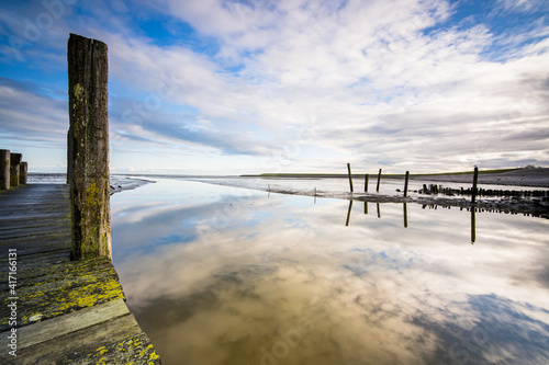 Small jetty with harbor along the coastline of the wadden island of Texel