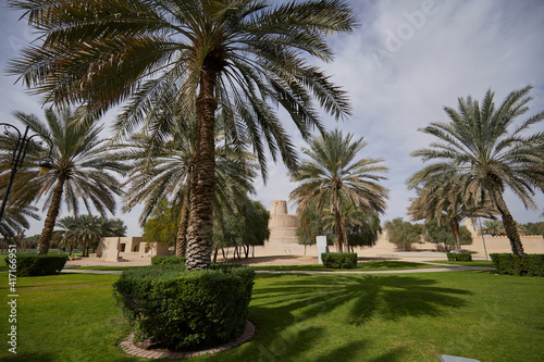 A view to the 'wedding cake' - like tower in Al Jahili Fort, in Al Ain, UAE, seen from a Palm Tree Park