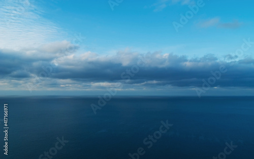 Dark blue sea surface under a cloudy sky.