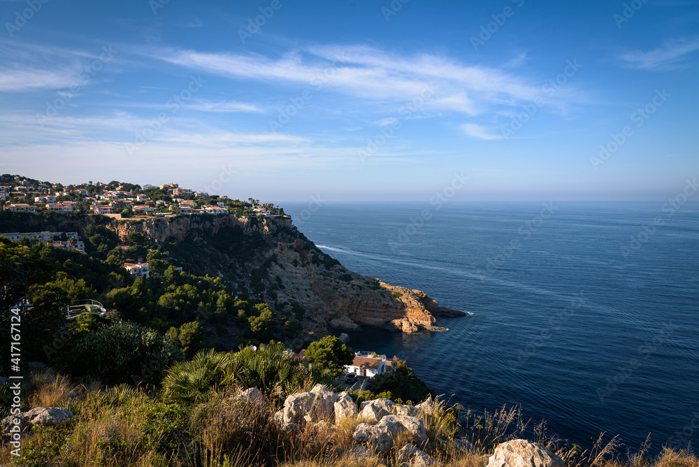 Fototapeta premium Residential area on top of a cliff on the coast of Javea on a summer day with blue sky, Javea, Alicante, Spain