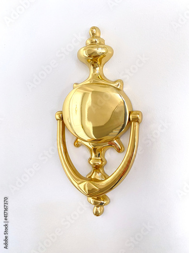 Fotografie Golden door knocker on white door