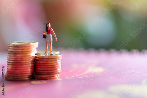 Miniature : woman standing on a coin Red background Financial concept