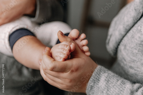 A young mother holds her baby's little foot