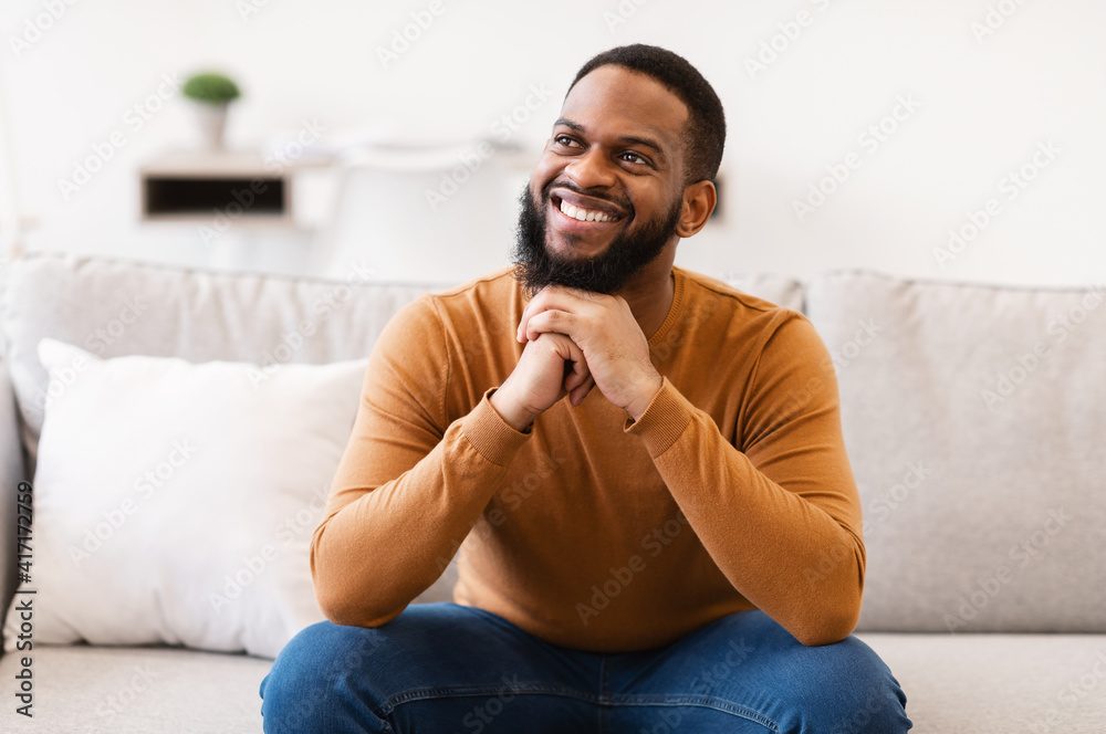 Dreamy Black Guy Thinking Sitting On Couch At Home