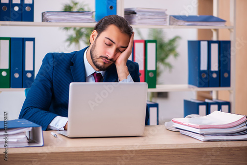 Young male employee and too many work in the office
