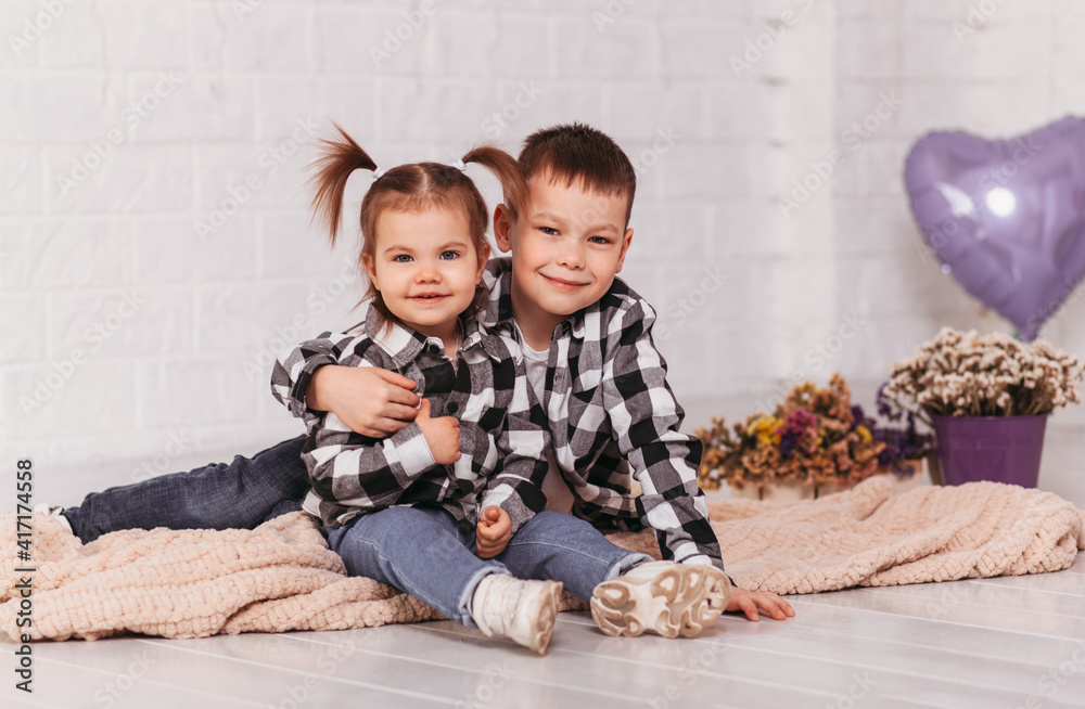 Boy and girl brother and sister sit and cuddle Boy and girl brother and sister sit and cuddle