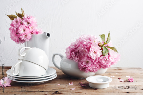 White cups, teapot and  Japanese cherry blossoms.