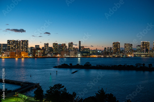 Tokyo Bay in the evening hours with a view of Tokyo skyline with tourists boards crossing the bay © Stefan
