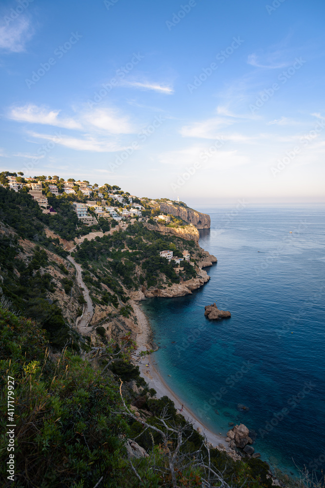 Residential area on top of a cliff on the coast of Cape Nao in Javea on a summer day with blue sky and clouds, Javea, Alicante, Spain
