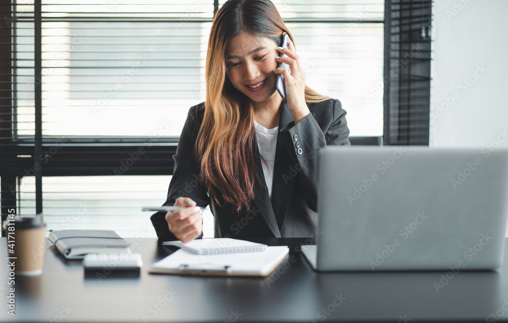 Asian Young business woman working at home with laptop and papers on desk Asian Young business woman working at home with laptop and papers on desk
