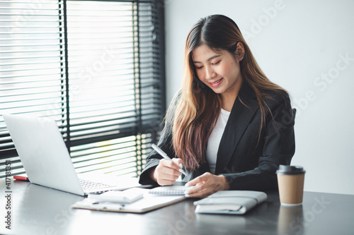 Asian young woman working on laptop in her home office