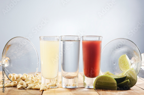 Set of three shot glasses known in Mexico as Bandera and served with lemon juice, tequila and sangria.