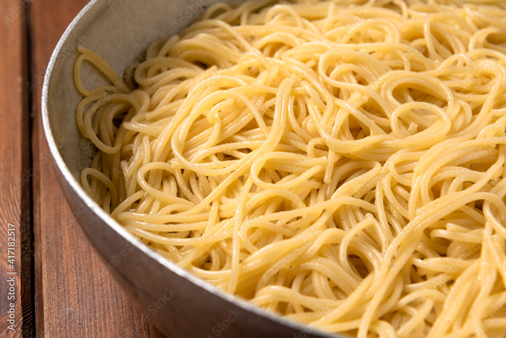 Padella con spaghetti all'aglio, olio e peperoncino, tipica ricetta di pasta italiana 