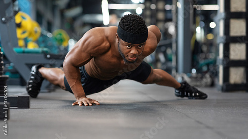 Motivated black guy bodybuilder doing some push-ups