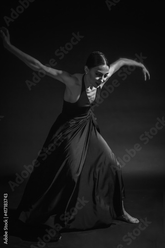 black and white dramatic vintage portrait of a girl  dancing ballerina in a black bodysuit in the Studio on gray background