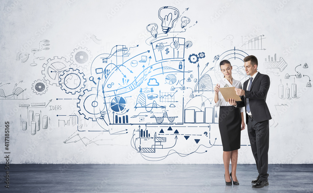 Man and woman discussing work near concrete wall with business strategy sketch Man and woman discussing work near concrete wall with business strategy sketch