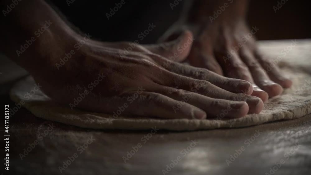 Male chef kneading homemade pizza dough on wooden table Slow Motion 60FPS