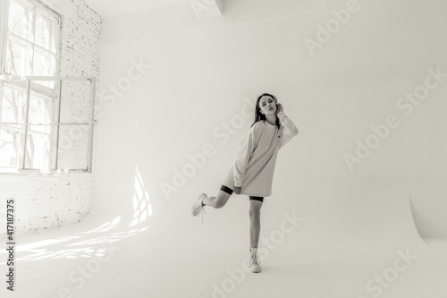 beautiful brunette girl in sportswear on a white background in a photo studio