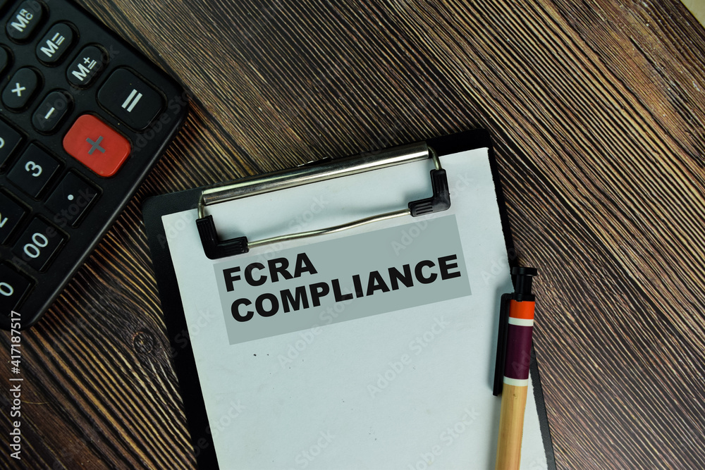 FCRA Compliance write on a paperwork isolated on Wooden Table.