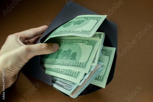Money in an envelope. Dollars in a black envelope. Concept: illegal salary. tax evader