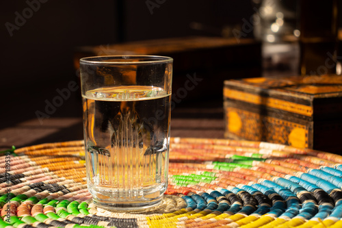 Fototapeta Naklejka Na Ścianę i Meble -  A glass of water on a Palestine home made rounded straw 